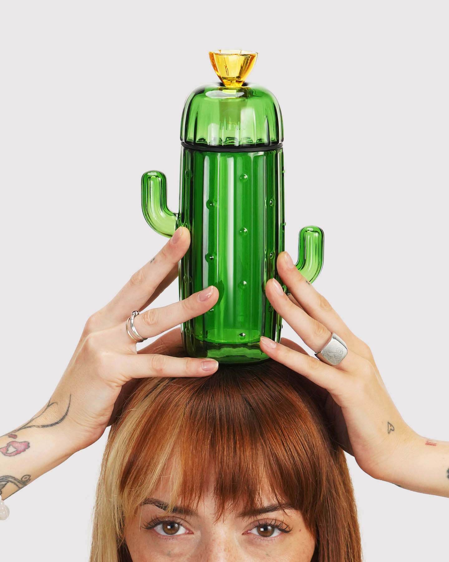 model holding cactus gravity bong above their head