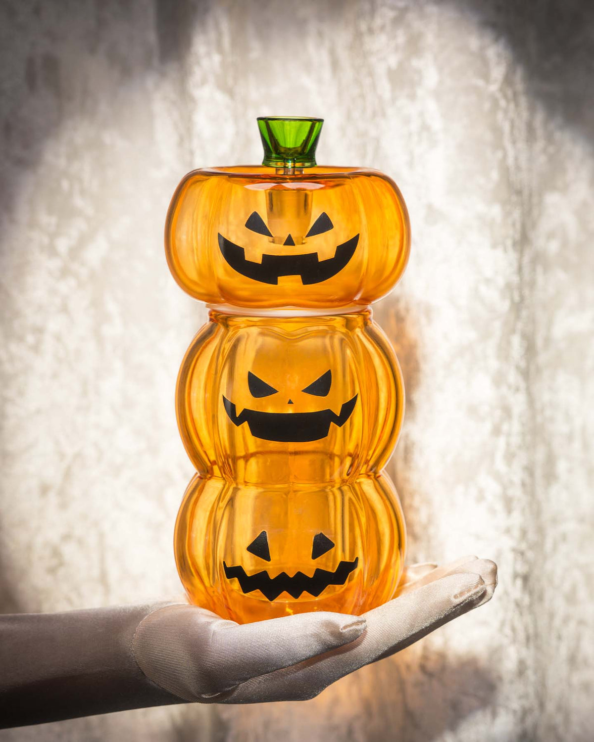 white gloved hand holding pumpkin gravity bong