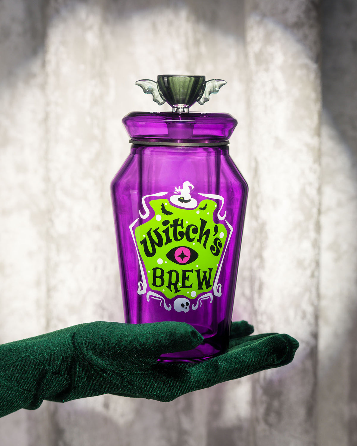 green gloved hand holding witch's brew gravity bong