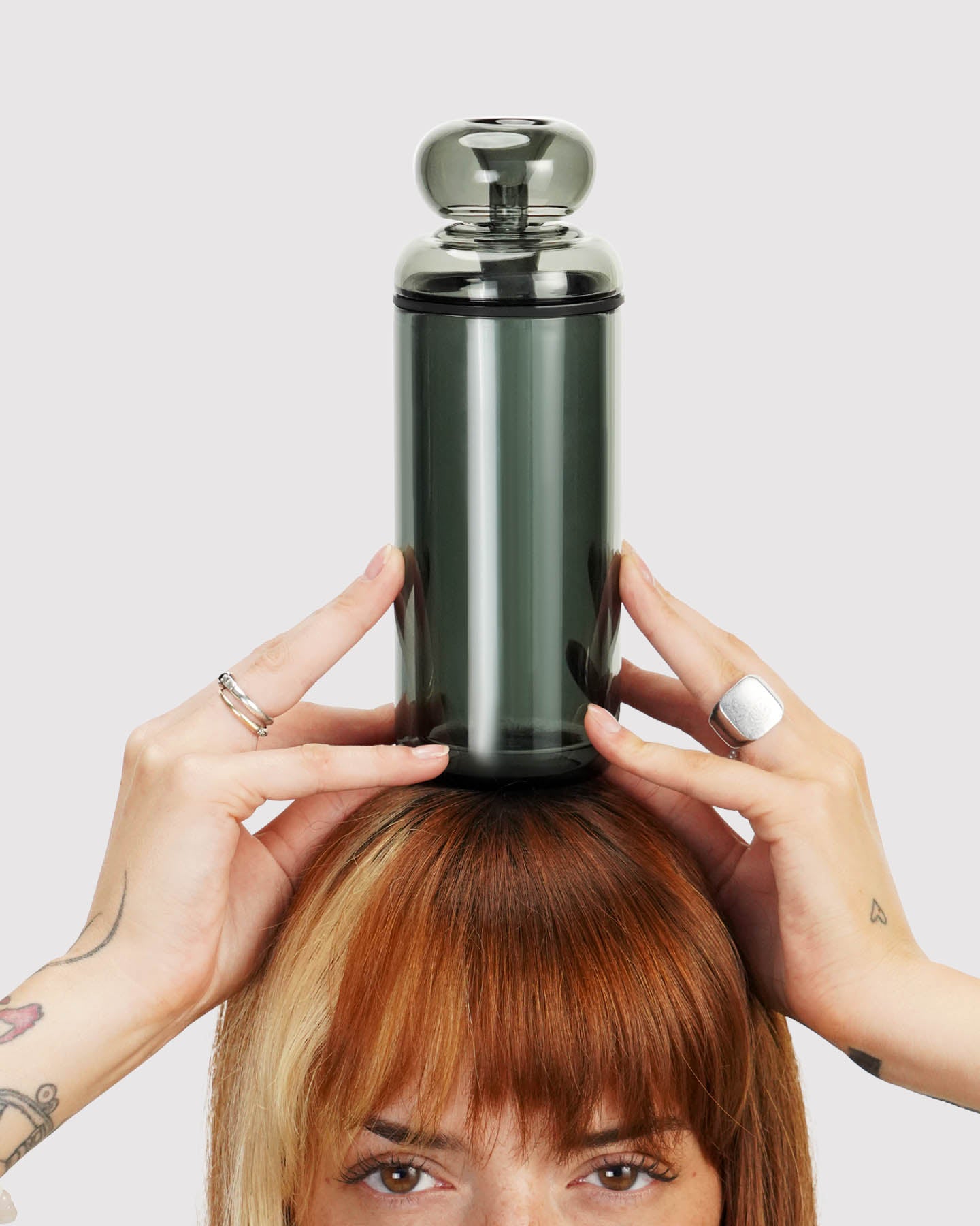model holding a black classic gravity bong above her head. 