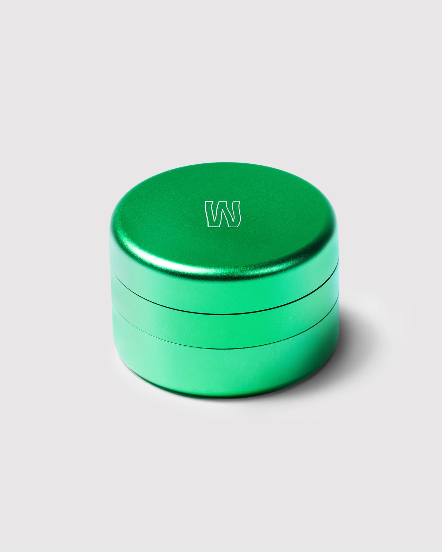 green 3 piece magnetic grinder against a white background 