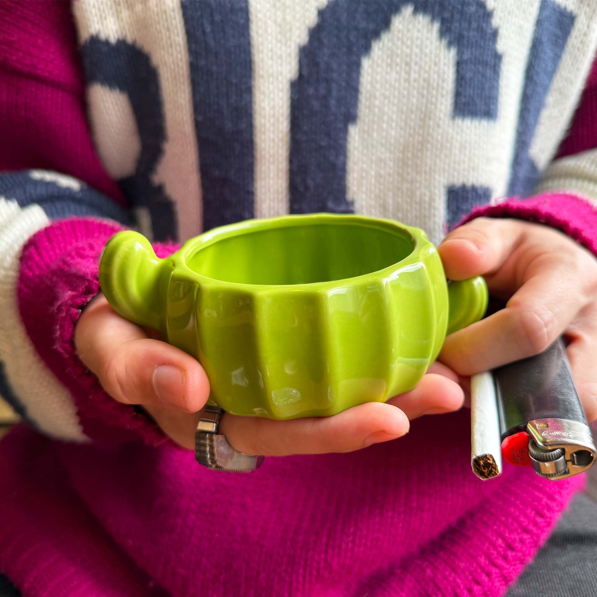 model holding cactus ash tray with cigarette and lighter in hand