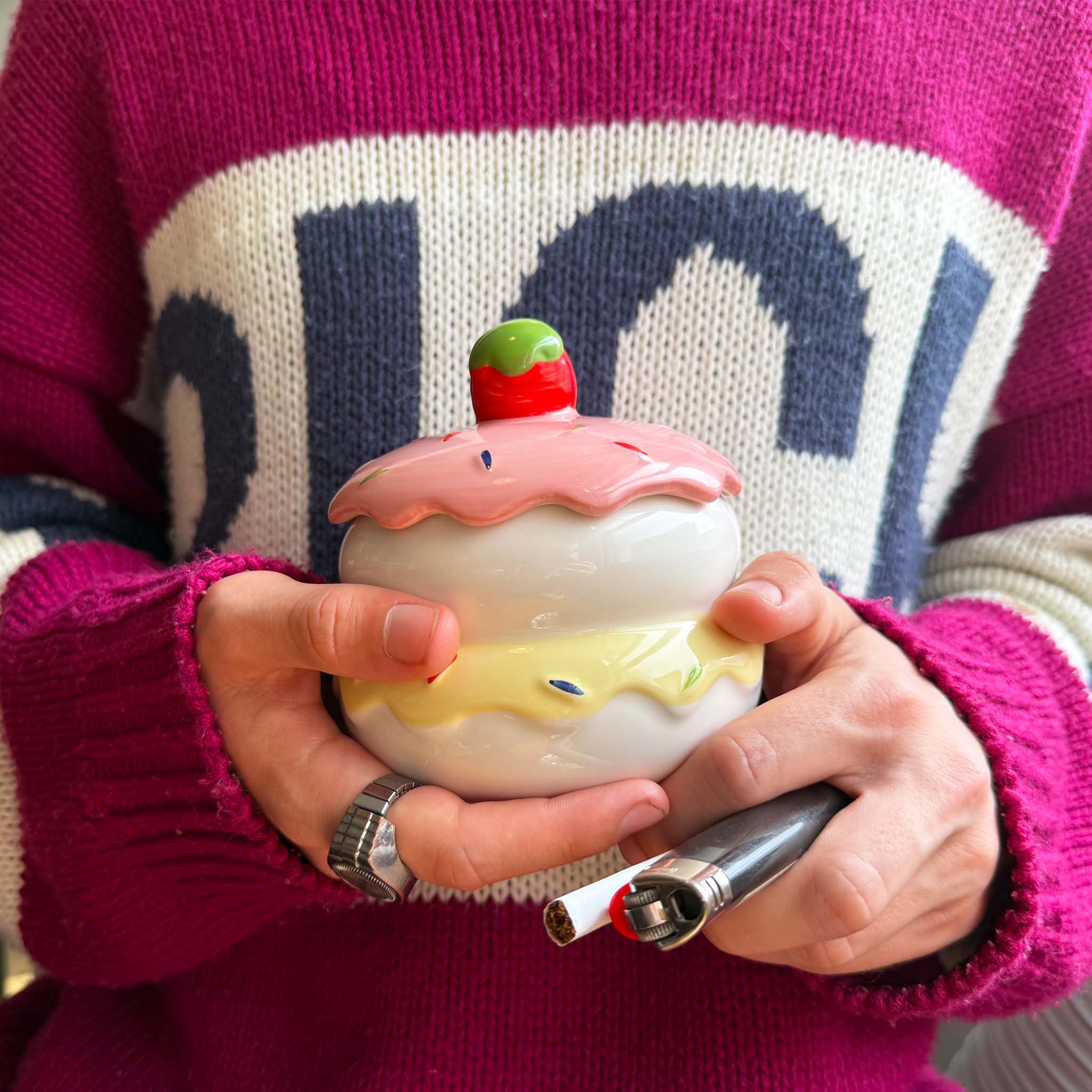 model holding cake ash tray with cigarette and lighter in hand 