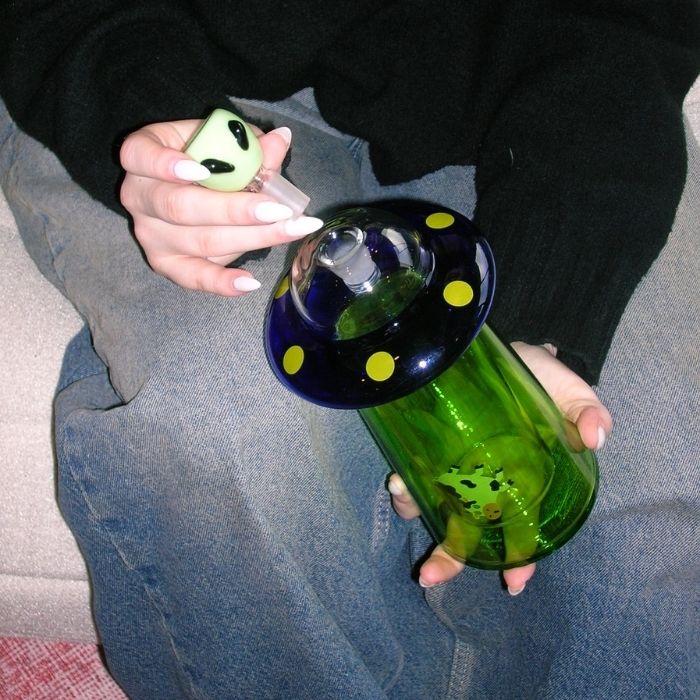 model holding ufo gravity bong and alien bowl 
