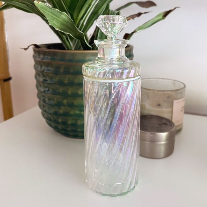 iridescent swirl gravity bong in front of candles and a plant 