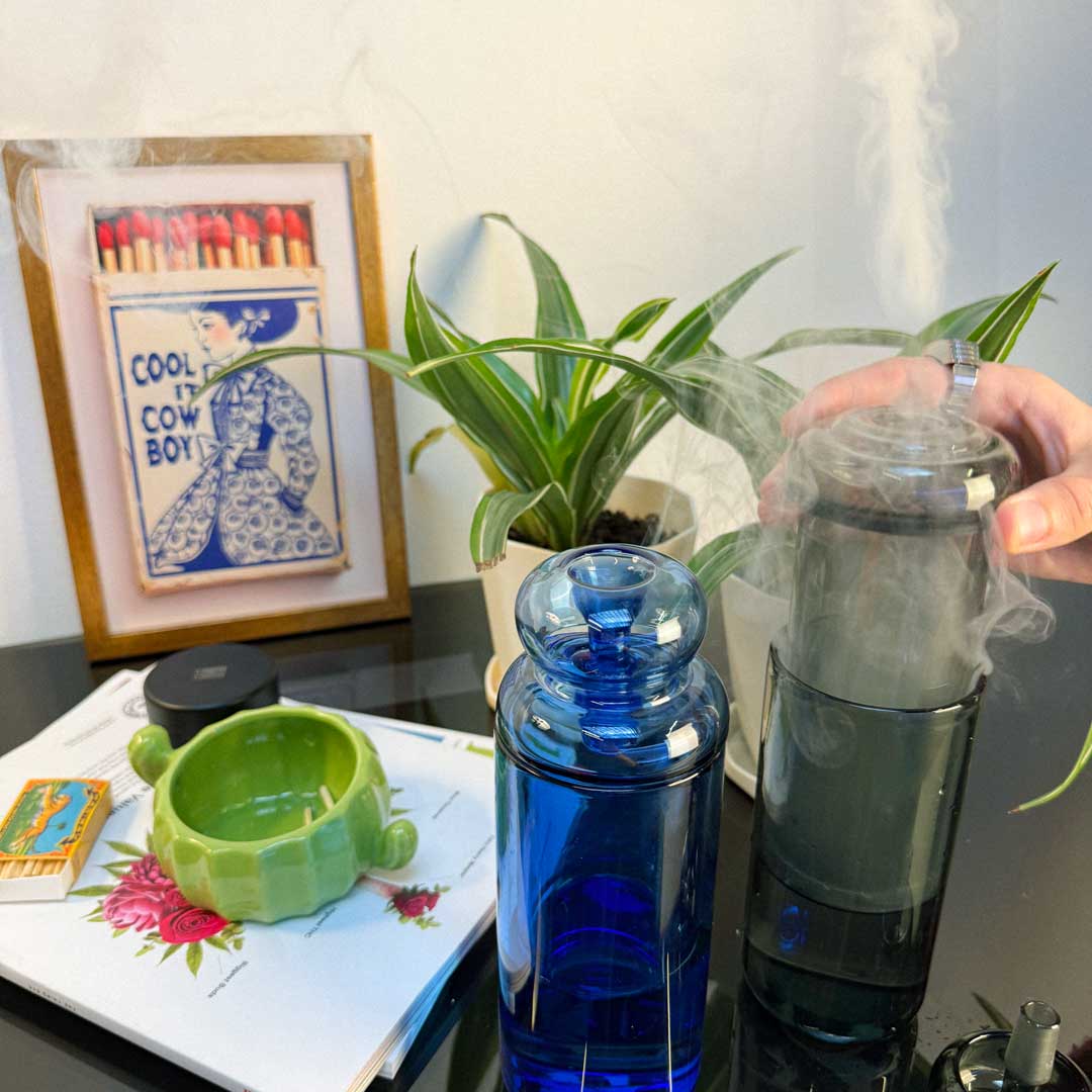 blue and black gravity bongs in use with cactus ash tray and black toothless grinder 